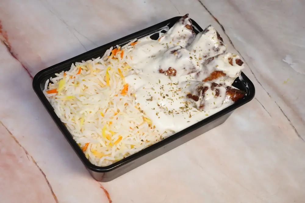 Malai seekh cream biryani packed in a delivery box with raita